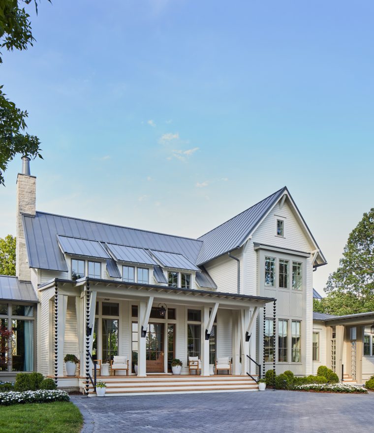 a large new luxury home with front porch and metal roof